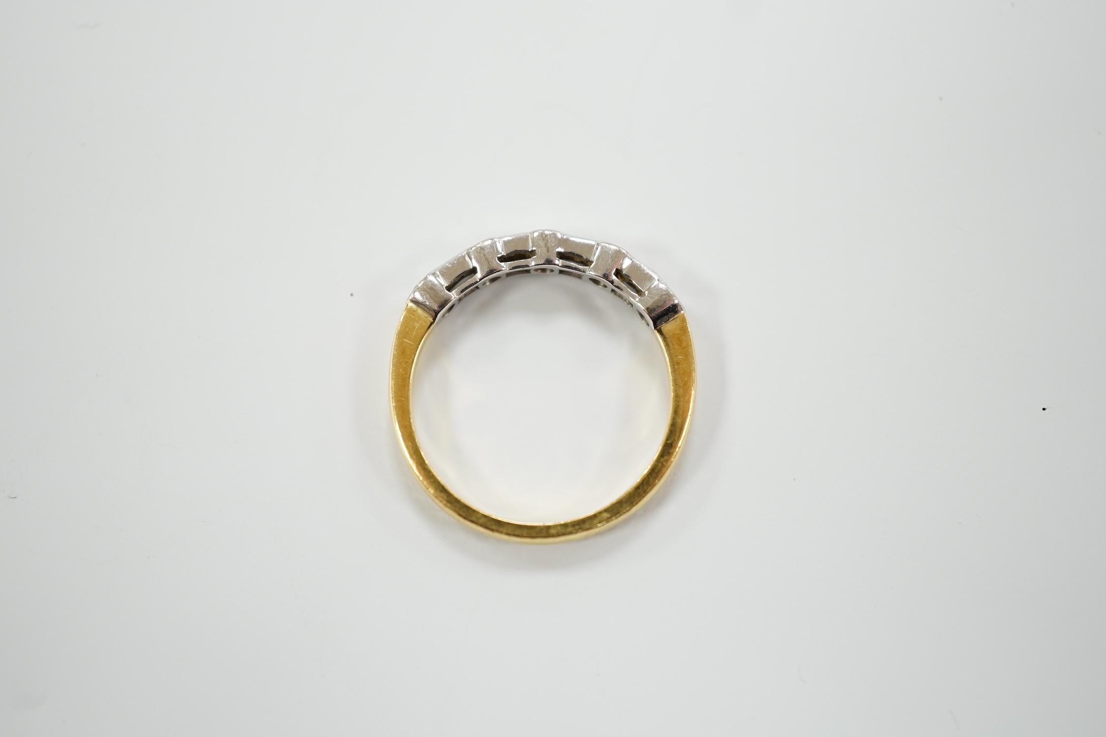 A modern 18ct gold, round and baguette cut diamond set half hoop ring, size N/O, gross weight 3.2 grams.